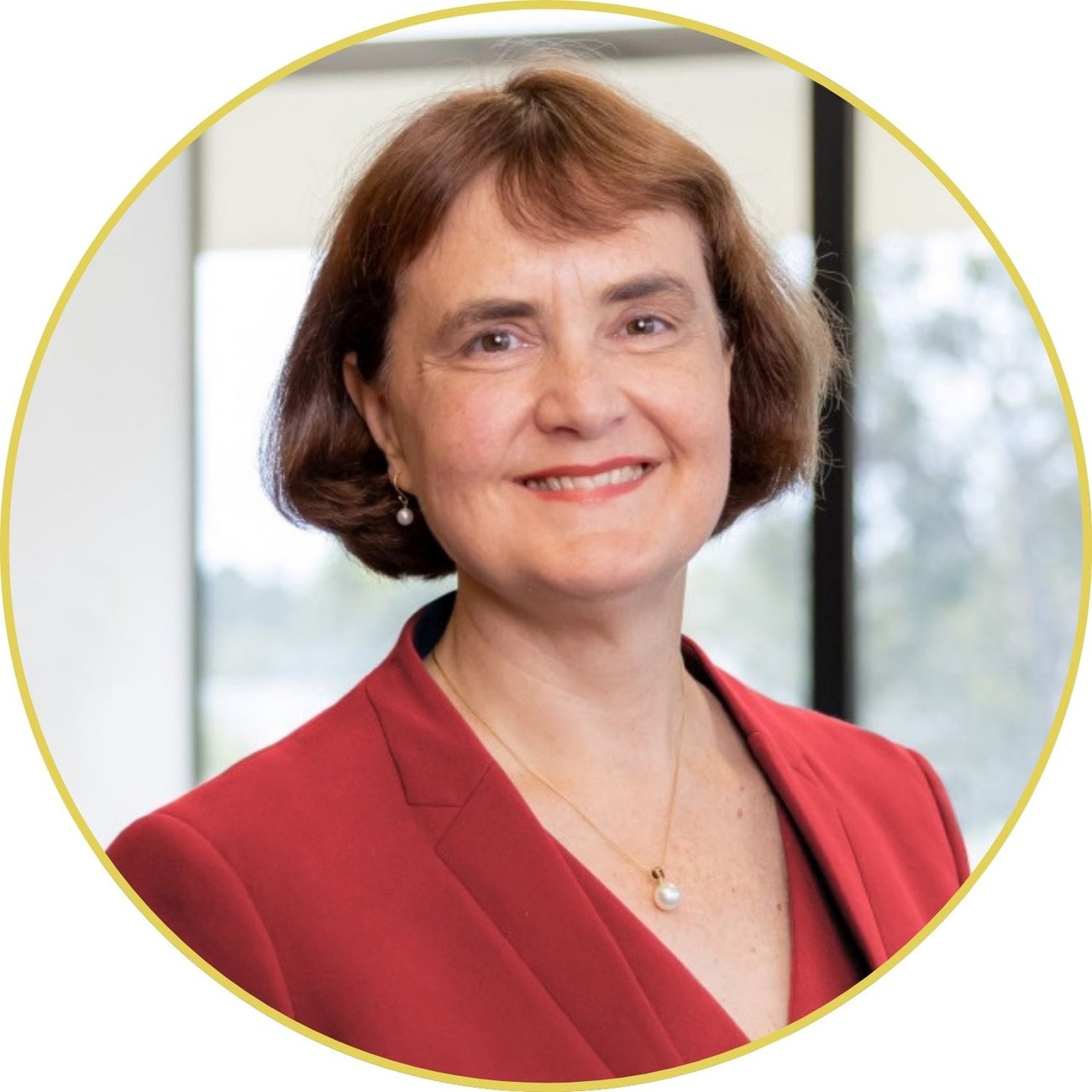 A headshot of Professor Carolyn Evans. She has pale skin, a short brown bob haircut and is wearing a red suit jacket.